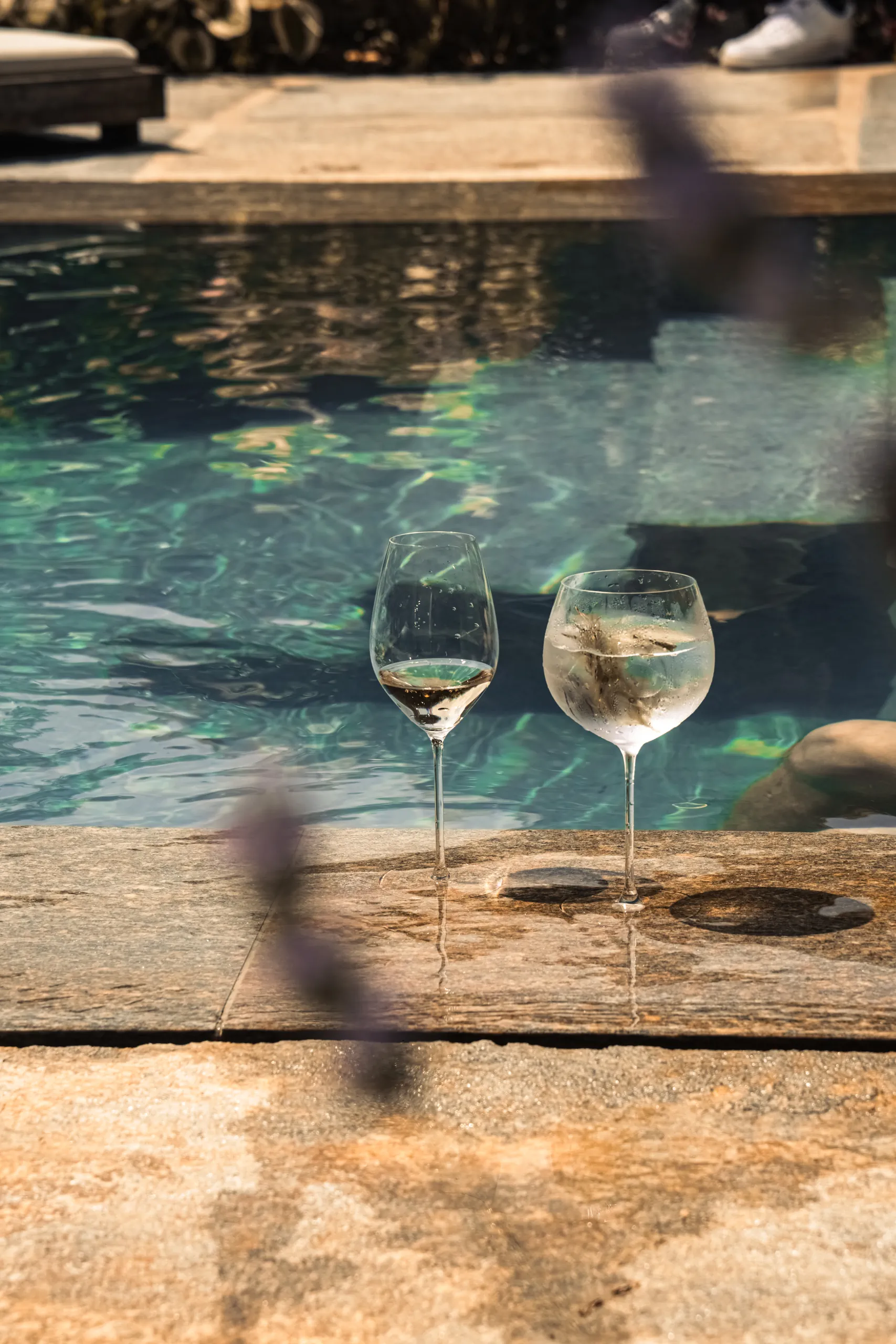 Two glasses of wine by the pool